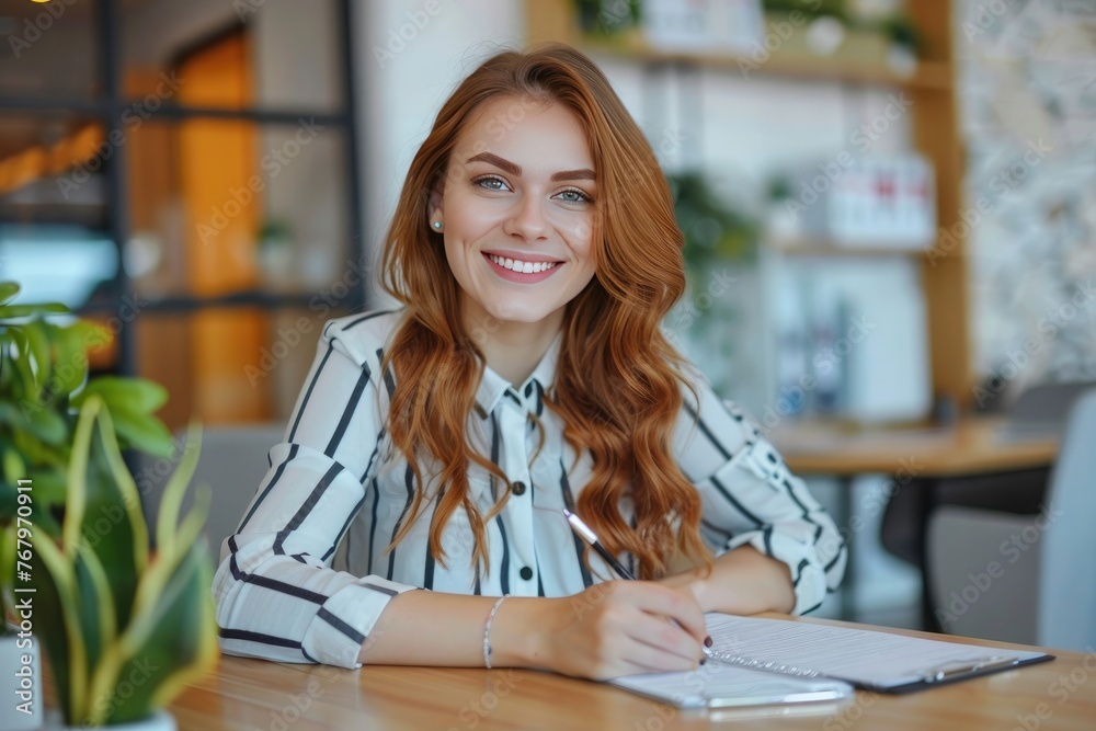 Image of smiling beautiful woman while sitting at table in office