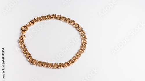 Round gold chain bracelet on a white surface