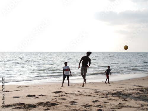 Boys and Kids playing football on the Beach 