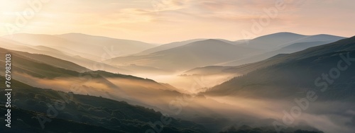 A serene mountain landscape at dawn, with mist rolling over gentle slopes. © Exnoi