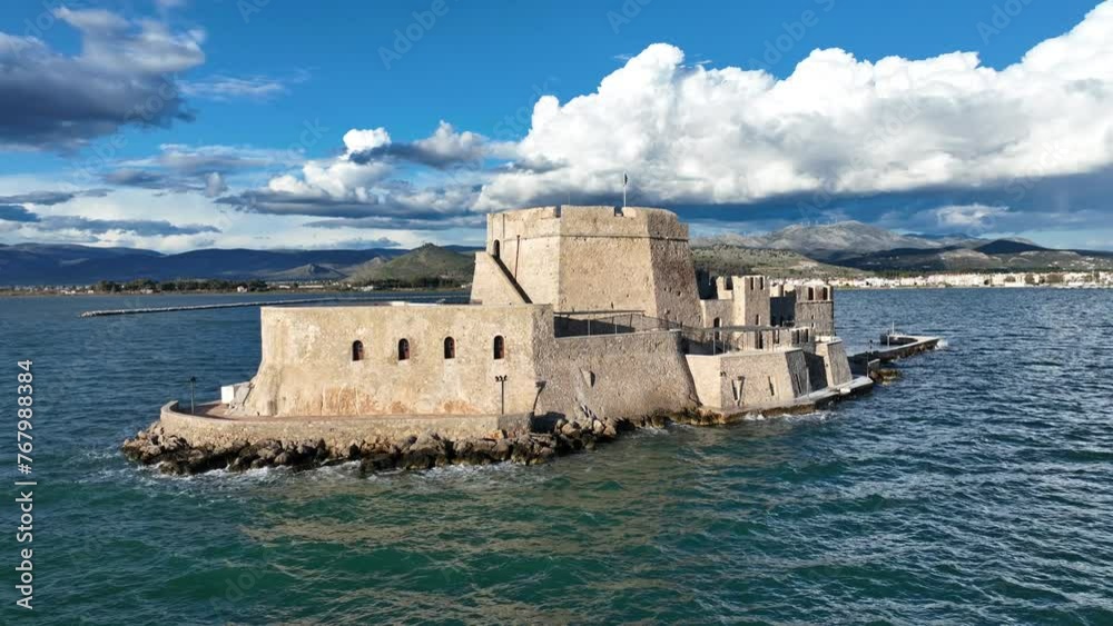 Aerial drone cinematic video of castle of Bourtzi built at sea a popular attraction in city of Nafplio as seen in the morning with nice white clouds and deep blue sky, Argolida, Greece Aerial drone cinematic video of castle of Bourtzi built at sea a popular attraction in city of Nafplio as seen in the morning with nice white clouds and deep blue sky, Argolida, Greece