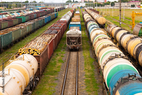 Tanks with fuel, wagons with cargo at a freight railway station. Logistics and transportation concept.