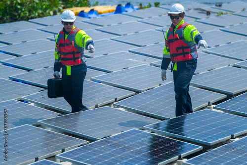 Wallpaper Mural Two technicians in reflective vests are conducting maintenance on a vast array of photovoltaic solar modules Torontodigital.ca