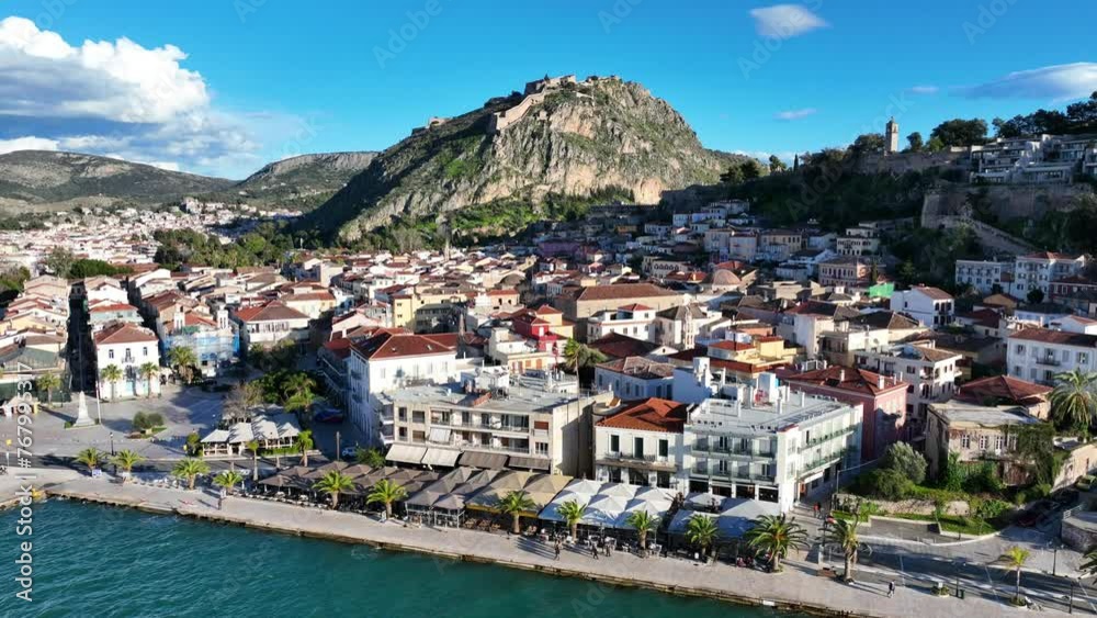 Aerial drone video of beautiful landmark castle of Palamidi built uphill overlooking iconic city of Nafplio in a nice spring morning with white clouds and deep blue sky, Argolida, Peloponnese, Greece