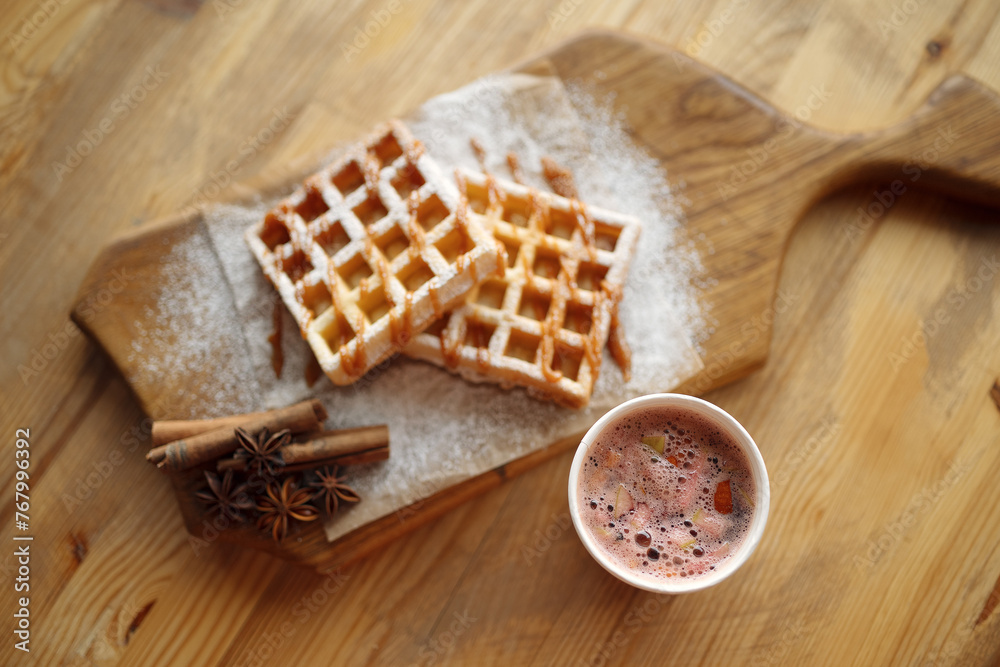 Waffles and mulled wine on a wooden table Waffles and mulled wine on a wooden table