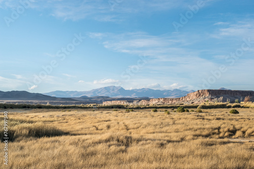 Valle con paredones naturales de rocas y montañas de fondo.  Luz solar. photo
