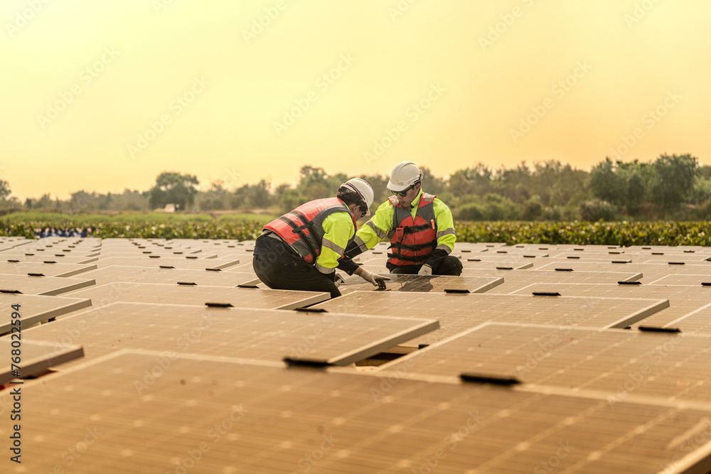 Photovoltaic engineers work on floating photovoltaics. workers Inspect and repair the solar panel equipment floating on water. Engineer working setup Floating solar panels Platform system on the lake.