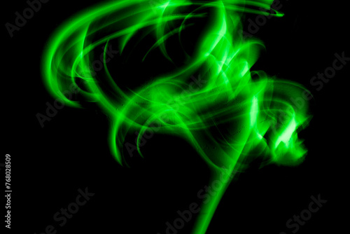 Abstract irregular green light on black background. Long exposure. Light painting photography.