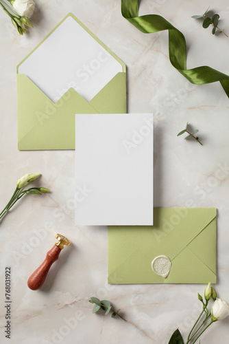 Wedding invitation card template with olive envelopes top view.