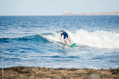 Front View of Young Man Surfing a Wave in a Sunny Day.Copy Space