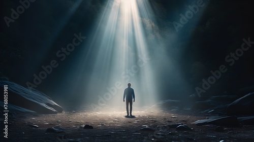 Man standing under celestial light rays - Mystical image of a man standing alone under powerful celestial light rays in a dark forest, evoking awe and wonder