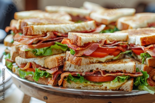 A closeup shot of a platter filled with delicious bacon and lettuce sandwiches
