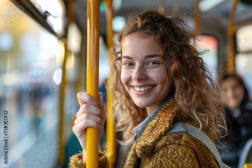 A young woman smiling while holding onto a handle on a public bus, indicative of daily commuting