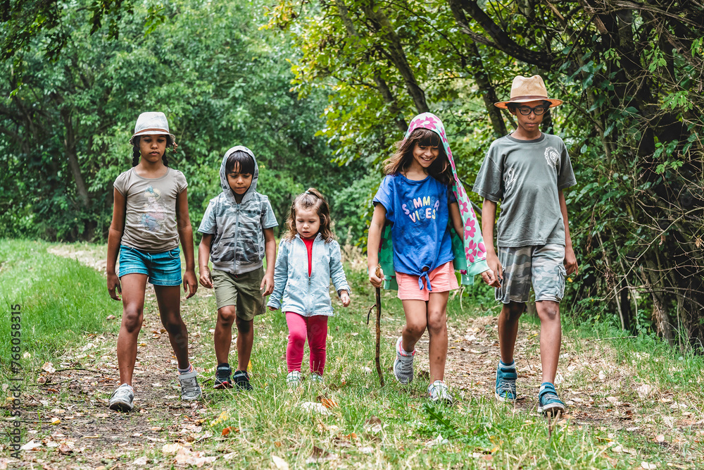 Trailblazing kids on a forest expedition. A diverse group marches on, embracing the joys of childhood and the spirit of summer adventures. Multiethnic group of happy wild kids