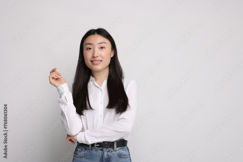 Portrait of smiling woman on light background. Space for text Portrait of smiling woman on light background. Space for text