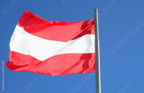 Austria flag with red and white stripes on background of the sky