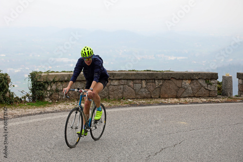 young cyclist boy with protective helmet pedals uphill on a racing bicycle during the race