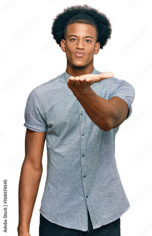 African american man with afro hair wearing casual clothes looking at the camera blowing a kiss with hand on air being lovely and sexy. love expression. African american man with afro hair wearing casual clothes looking at the camera blowing a kiss with hand on air being lovely and sexy. love expression.