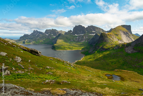 Mountain lakes in Lofoten islands, Nordland, Norway. Alpine lake surrounded by the scenic nature with moss, water and peaks. Hiking in wild nature of Lofoten islands.