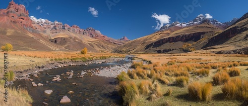  A river in the center of a valley surrounded by mountains and green grass in the foreground