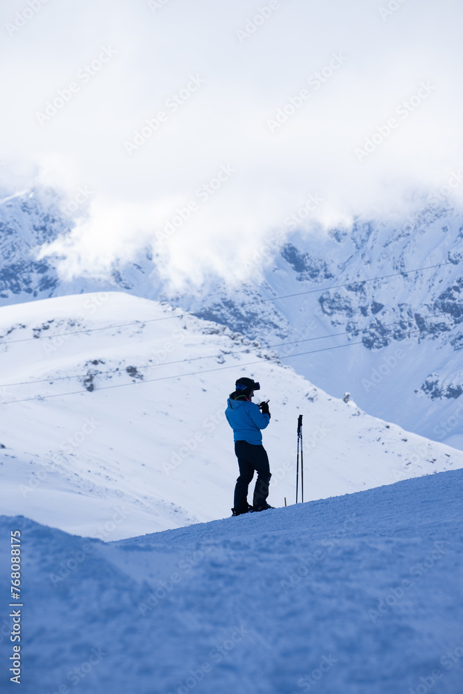 Skier against mountains with clouds