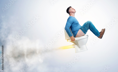 A funny man in casual clothes flies up sitting on the toilet leaving exhaust and smoke in his wake. On light background.