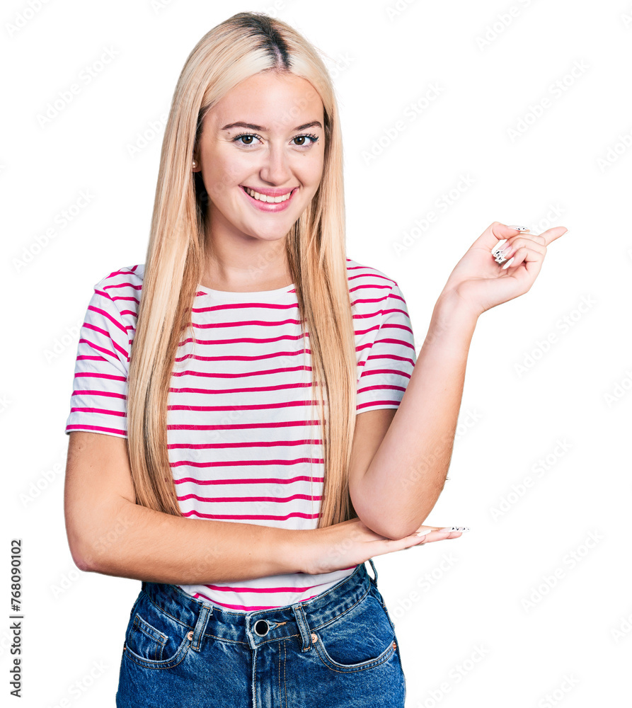 Beautiful blonde woman wearing casual striped t shirt with a big smile on face, pointing with hand and finger to the side looking at the camera. Beautiful blonde woman wearing casual striped t shirt with a big smile on face, pointing with hand and finger to the side looking at the camera.