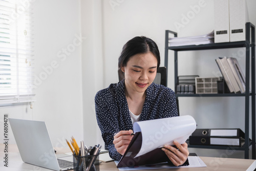 Businesswoman working on laptop analyzing chart and graph files.