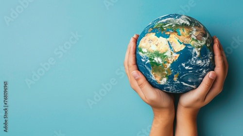 Hands embrace Earth globe against calm blue, signifying unity in environmental conservation, with ample copy space