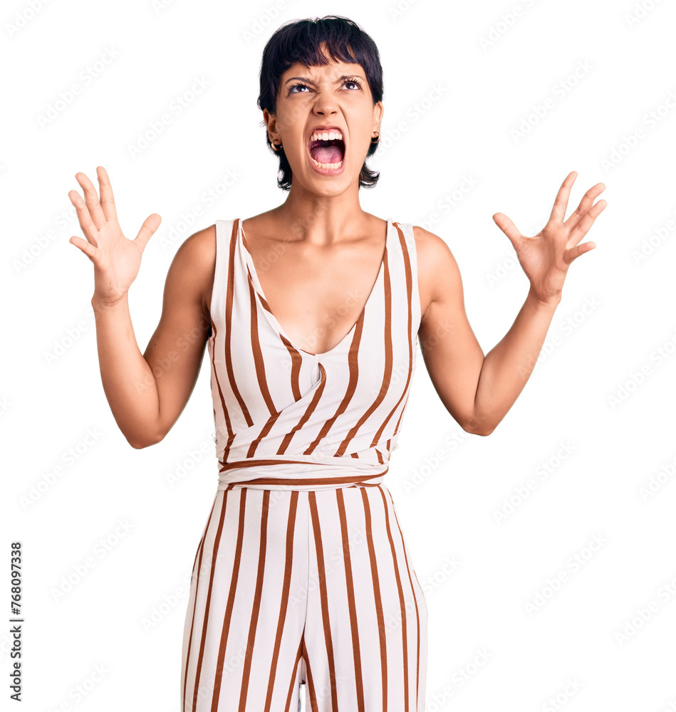 Young brunette woman with short hair wearing summer outfit crazy and mad shouting and yelling with aggressive expression and arms raised. frustration concept. Young brunette woman with short hair wearing summer outfit crazy and mad shouting and yelling with aggressive expression and arms raised. frustration concept.