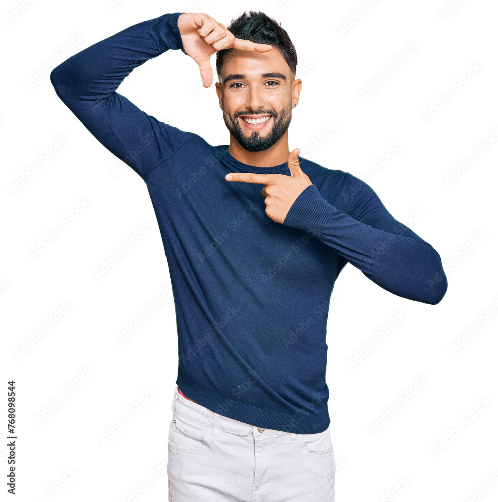 Young man with beard wearing casual blue winter sweater smiling making frame with hands and fingers with happy face. creativity and photography concept. Young man with beard wearing casual blue winter sweater smiling making frame with hands and fingers with happy face. creativity and photography concept.