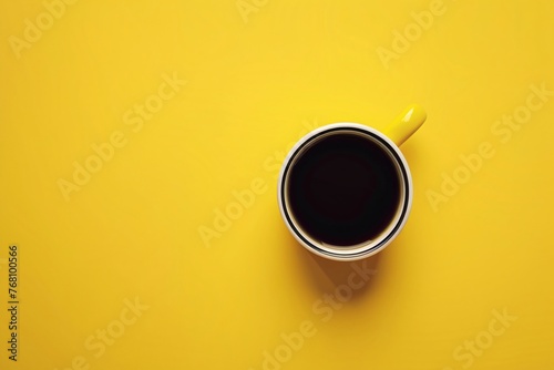 a cup of coffee on a yellow surface