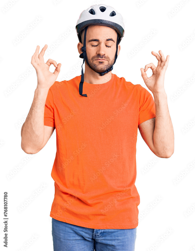 Young handsome man wearing bike helmet relax and smiling with eyes closed doing meditation gesture with fingers. yoga concept. Young handsome man wearing bike helmet relax and smiling with eyes closed doing meditation gesture with fingers. yoga concept.