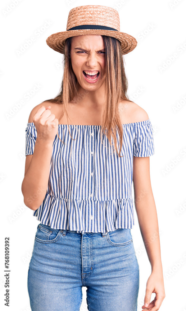 Young beautiful girl wearing hat and t shirt angry and mad raising fist frustrated and furious while shouting with anger. rage and aggressive concept. Young beautiful girl wearing hat and t shirt angry and mad raising fist frustrated and furious while shouting with anger. rage and aggressive concept.