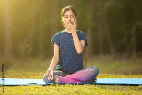 indian ethnicity women concentrating on pranayama meditation by focusing on breath inhale and exhale and sitting in a ardha padmasana position, eyes closed
