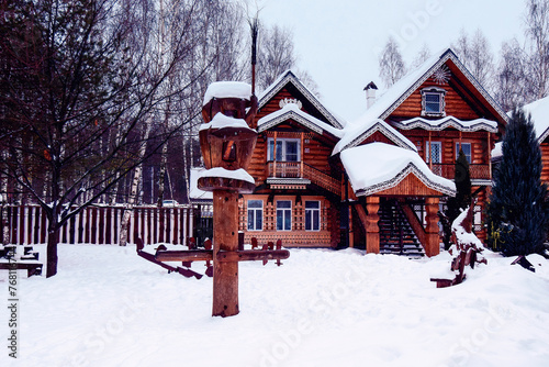 wooden carousel and carved house in a snow-covered park