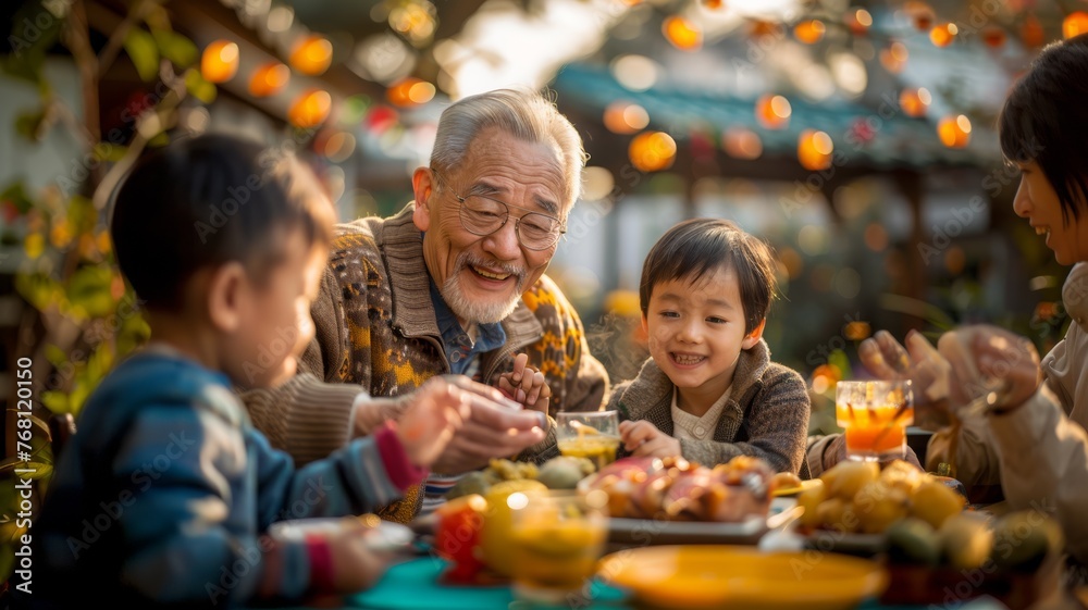 Obraz premium asian grandfather with 2 small children in a summer day in a family celebration