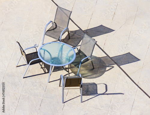 Shadow on the floor from a glass table with chairs