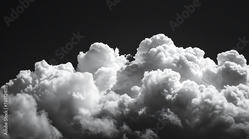 A grayscale photo of clouds. The clouds are fluffy and look like they are backlit by the sun.