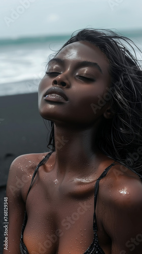 Woman with wet skin on a black beach