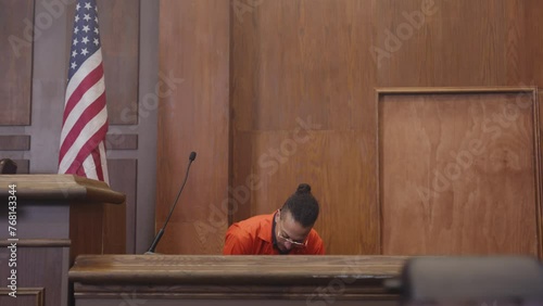 Black man on trial sitting down on the stand photo