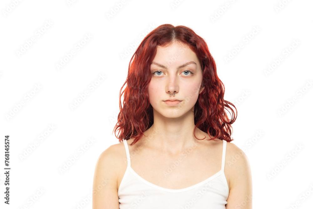 Portrait of a young serious woman without makeup and long red wavy hair on a white background Portrait of a young serious woman without makeup and long red wavy hair on a white background