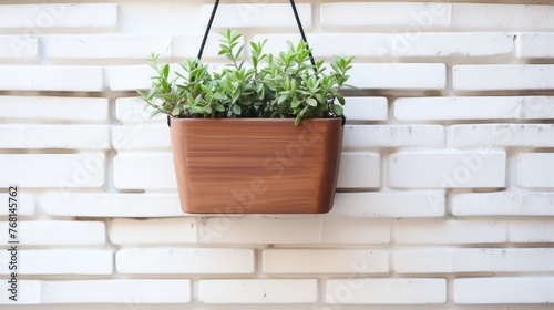 Wooden plant pot hanging in front of an white brick wall