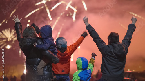 Excited happy family with kids watch and enjoy the New Year Eve night fireworks show