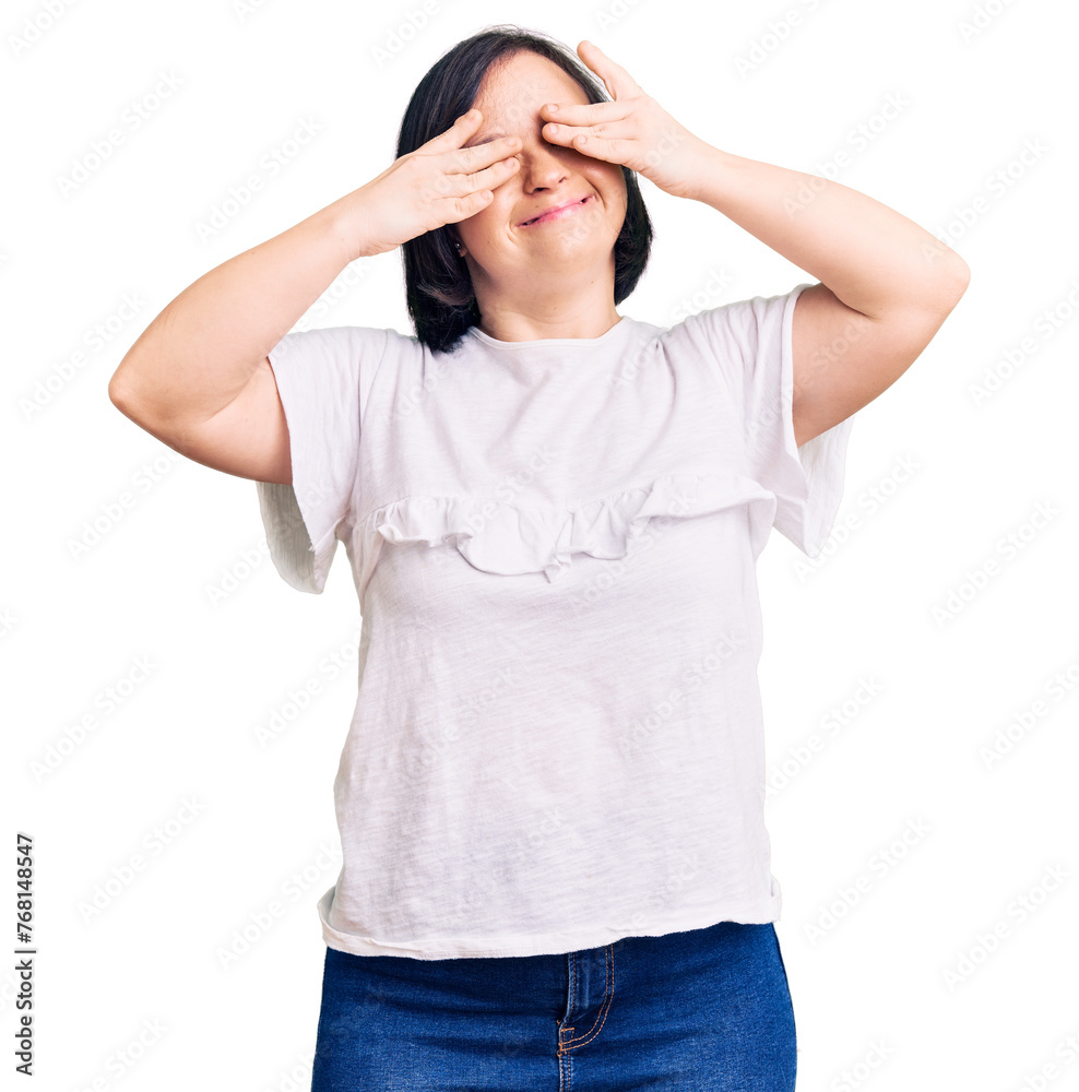 Brunette woman with down syndrome wearing casual white tshirt covering eyes with hands smiling cheerful and funny. blind concept. Brunette woman with down syndrome wearing casual white tshirt covering eyes with hands smiling cheerful and funny. blind concept.