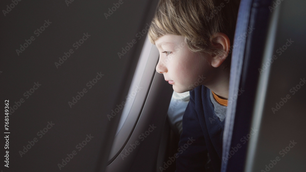 Cute child watching on airplane window