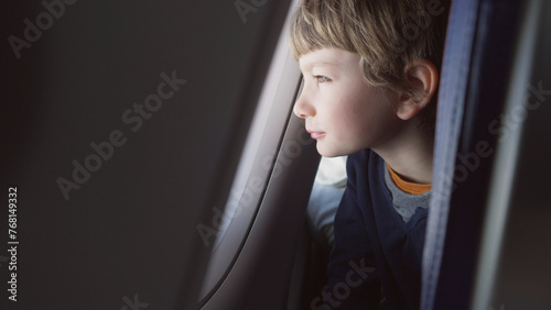 Little kid watching on airplane window