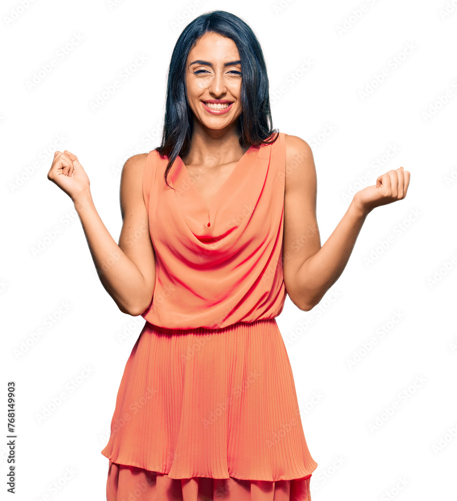 Beautiful hispanic woman wearing summer dress very happy and excited doing winner gesture with arms raised, smiling and screaming for success. celebration concept.