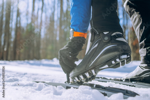 Canvas Print Close-up of Cross-Country Skier Fastening Ski Boots in Snow