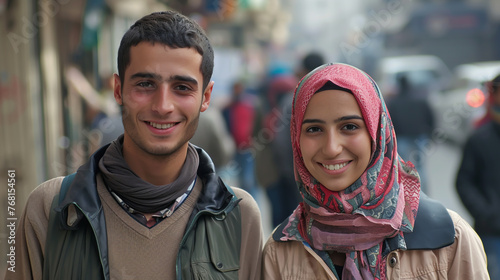 A smiling Middle Eastern couple poses for the camera.